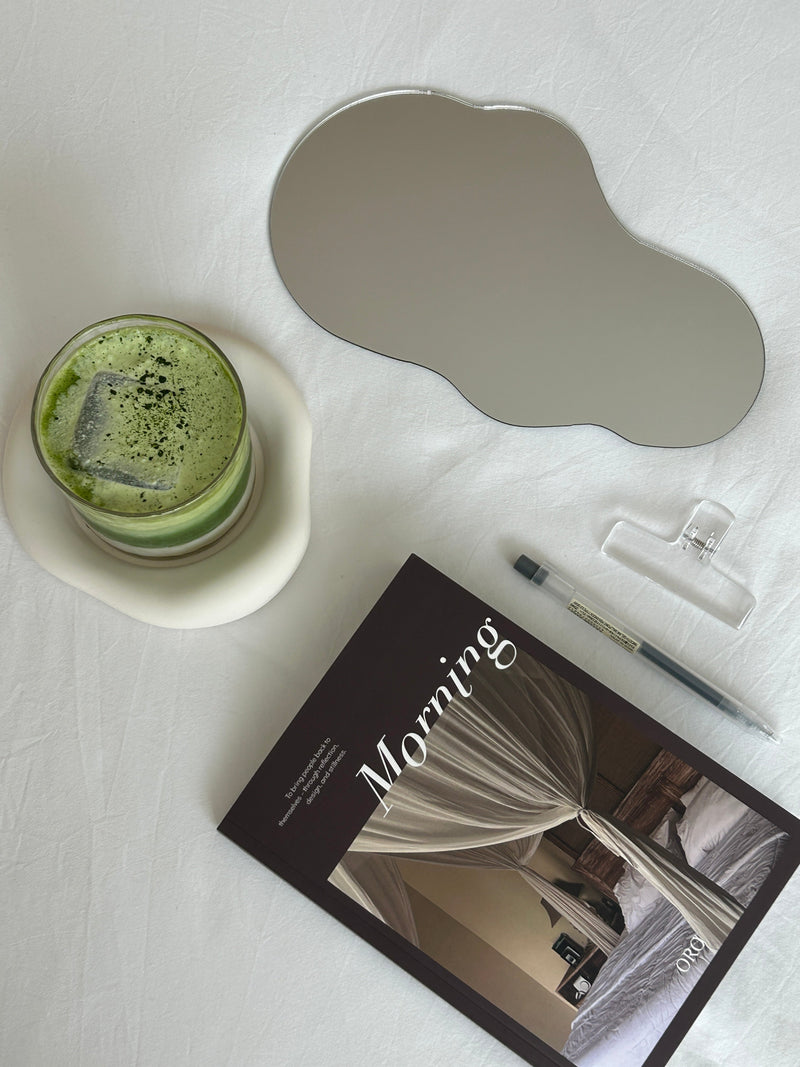 An open journal and pen resting on a bedside table in soft morning light.